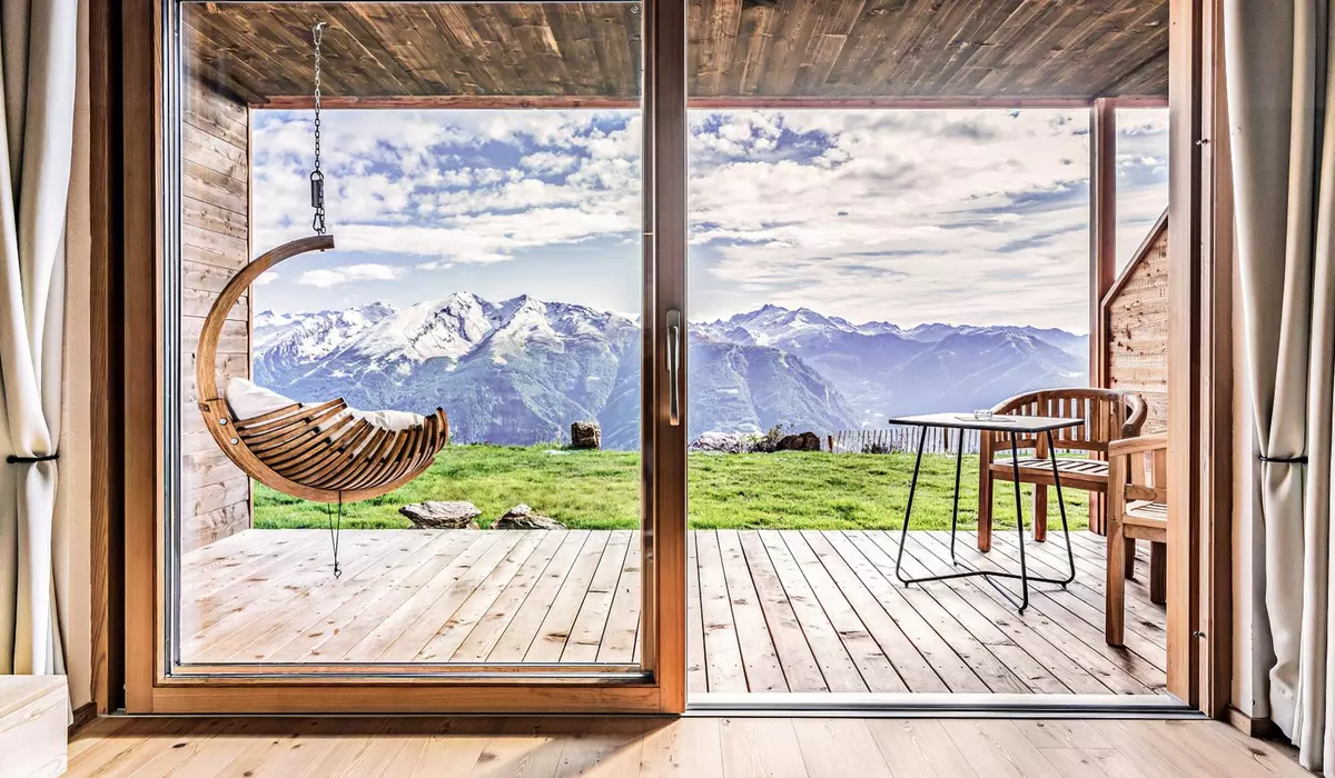 Fensterfront mit Schwebestuhl in der comfort Suite 6 im Mountain Chalet Stern am Rosskopf